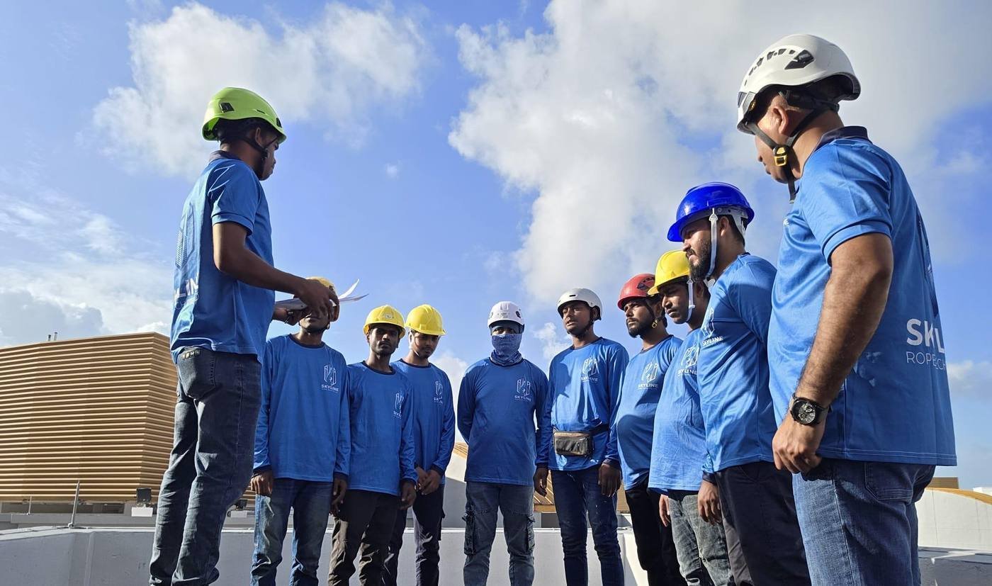 certified Skyline Rope Tech crew briefing on a Singapore rooftop before rope access work