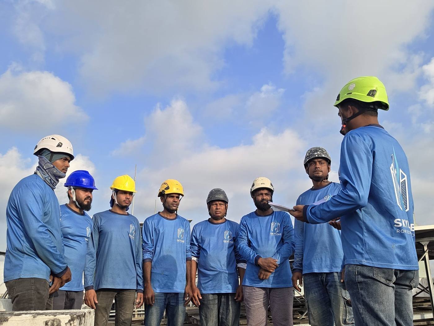 Skyline Rope Tech supervisors briefing the rope access crew on a Singapore rooftop before survey